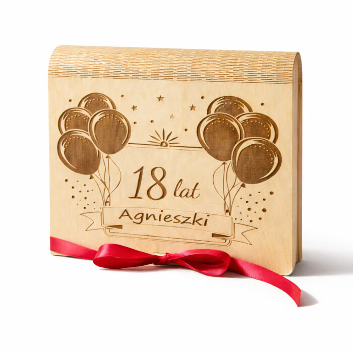 Drewniane pudełko prezentowe ozdobione czerwoną wstążką, które nadaje całości elegancki i uroczysty wygląd.