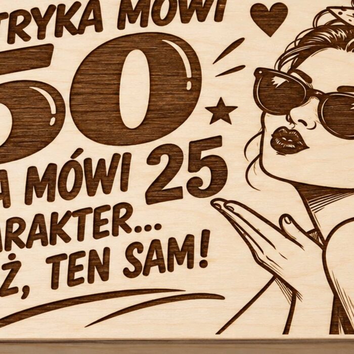Zbliżenie grawerowanego wieczka pudełka na 50 urodziny z postacią kobiety